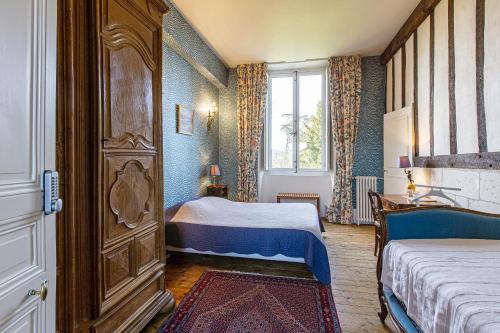 - une petite chambre avec 2 lits et une fenêtre dans l'établissement Manoir de la Voute maison d'hôtes, à Pouillé