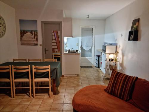 ein Wohnzimmer mit einem Tisch und einer Küche in der Unterkunft La commanderie in La Tranche-sur-Mer
