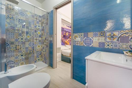 a bathroom with a sink and a toilet and blue tiles at La casa del postino in Procida