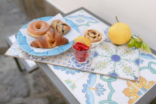 a table with a plate of pastries and a drink at La casa del postino in Procida
