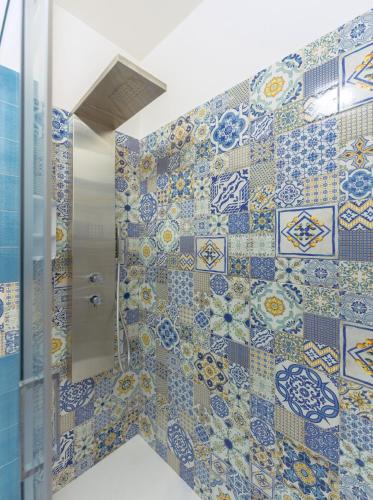 a bathroom with a shower with blue and white tiles at La casa del postino in Procida