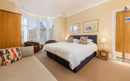 a bedroom with a bed, chair, and a window at The Gables Guest House in Ambleside