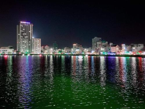 a city skyline at night with a large body of water at HOSTEL ARIA in Quy Nhon