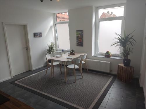 a dining room with a table and two windows at FeWo Engler Lauenburg Bahnhofstraße in Lauenburg
