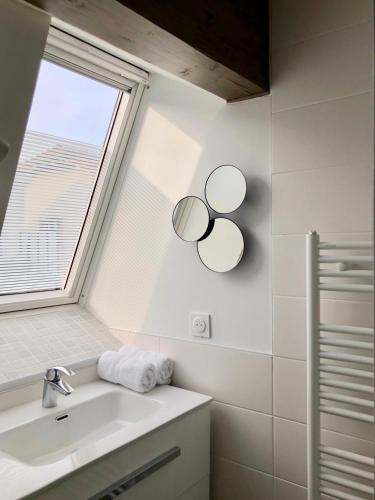 une salle de bain blanche avec un lavabo et une fenêtre dans l'établissement T2 en duplex & terrasse, à Saint-Priest