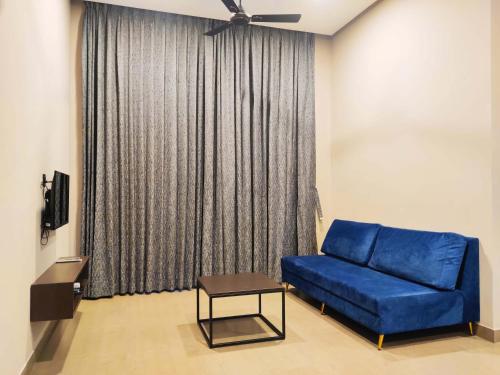 a living room with a blue couch and a window at VAMA Retreats in Bengaluru