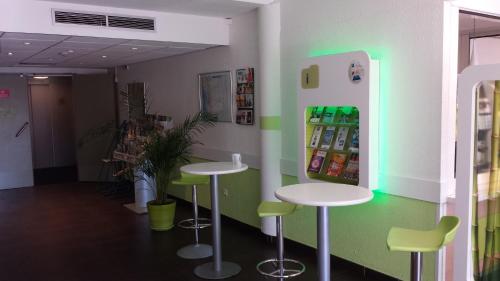a room with two tables and a refrigerator at Ibis Budget Marseille Valentine in Marseille