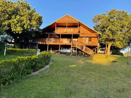 ein großes Holzhaus mit einem Hof davor in der Unterkunft Kosy place in KwaMazambane