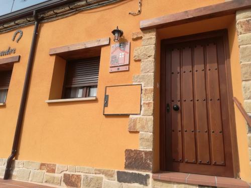 un edificio con una puerta marrón y una ventana en La casita del herrador, en El Burgo de Osma