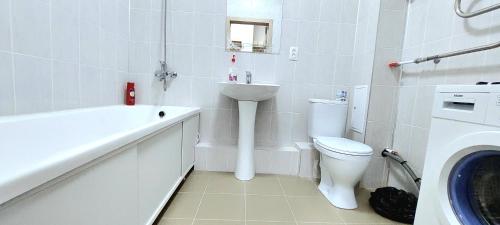 a white bathroom with a toilet and a sink at Будапешт 197 in Prigorodnyy