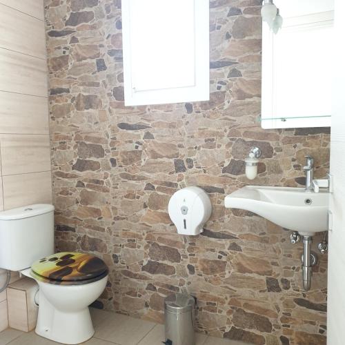 a bathroom with a toilet and a sink at Petrino Studios in Keramotí