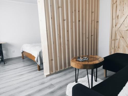a living room with a table and a bed at Apartament w ogrodzie in Tylka