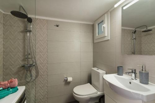 łazienka z toaletą i umywalką w obiekcie Sirens Athens Apartment w Atenach