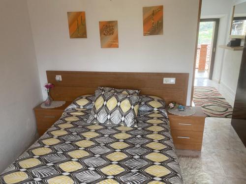 a bedroom with a bed with a black and yellow comforter at Casa Rural La Corrada in Llamoso
