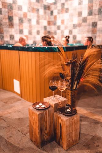 two glasses of wine on wooden stools next to a bar at Dakota forest retreat in Tsigov Chark