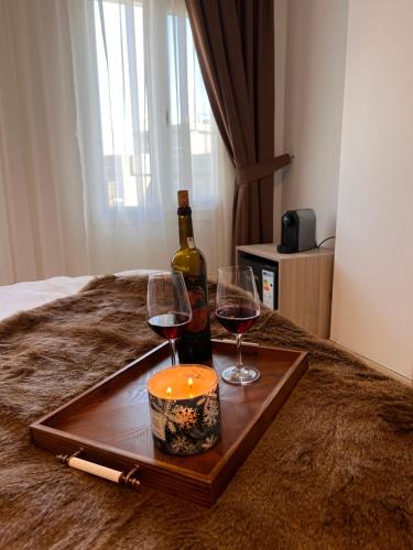 a tray with a bottle of wine and two glasses at B. Equine Range Hotel in Narlıdere
