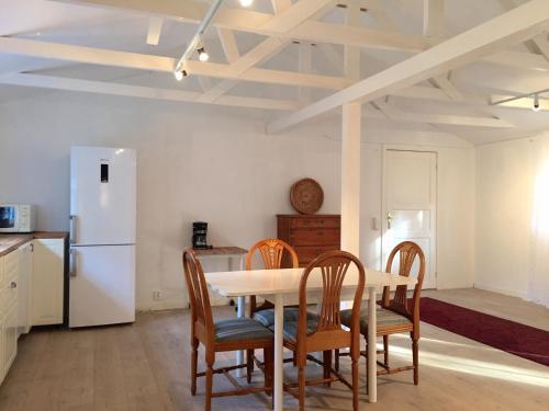 a kitchen with a table and chairs and a refrigerator at Galleri huset studio in Blankaholm