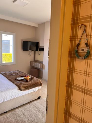 a bedroom with a bed and a guitar on the wall at B. Equine Range Hotel in Narlıdere