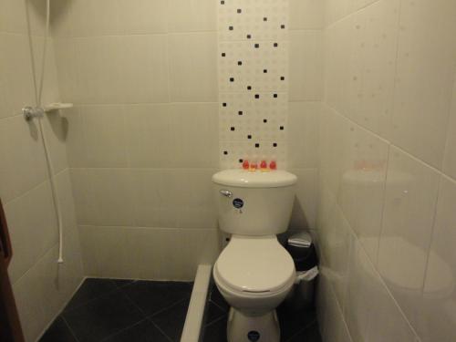 a white bathroom with a toilet and a shower at Casa de Huespedes Villa Hermosa in La Vega