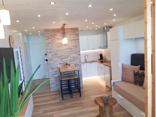a living room and kitchen with a couch and a table at Magnifique Studio Face Mer avec Place Privative. in Saint-Jean-de-Monts