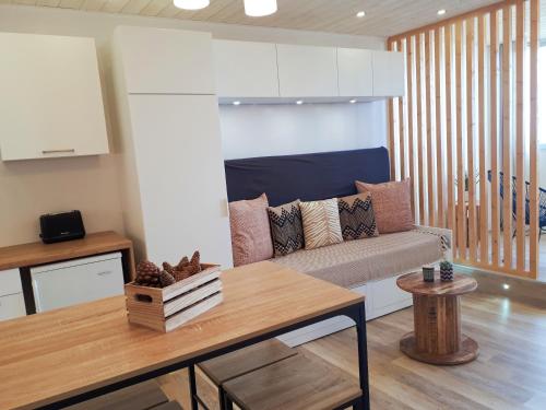 ein Wohnzimmer mit einem Sofa und einem Tisch in der Unterkunft Magnifique Studio Face Mer avec Place Privative. in Saint-Jean-de-Monts