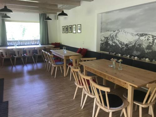 a row of tables and chairs in a restaurant at Kleine Ferienwohnung am Rande der Wildnis in Sibratsgfäll