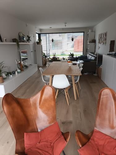 Una cocina y una sala de estar con mesa y sillas. en VERADEMING, en Bilzen
