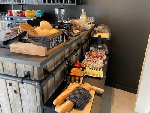 a bakery with bread and other food on a counter at Rouleur Houffalize in Houffalize