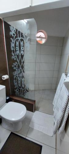 a bathroom with a white toilet and a shower at Lush Garden Villa with private pool in Trou aux Biches