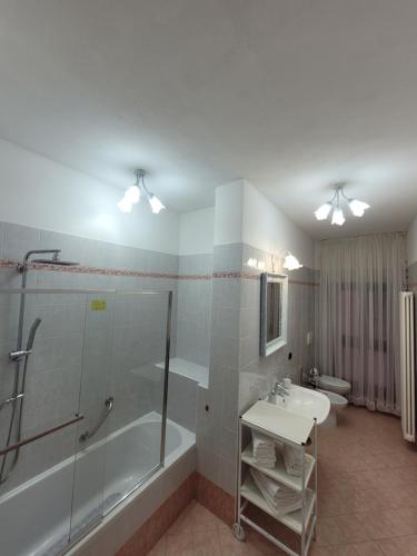 y baño con ducha, bañera y lavamanos. en Casa BuIIo, en Chioggia