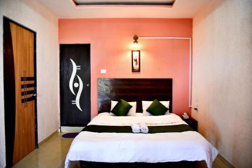 una camera con un grande letto su una parete rossa di MERIDIAN AC VILLA - Besides Valley View & Strawberry Farms a Mahabaleshwar