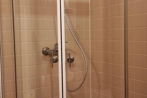 a shower with a glass door and a shower coil at Уютен апартамент близо до морето IGROEG in Burgas City