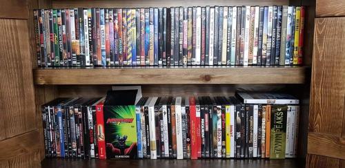 a book shelf filled with lots of dvds at Casa Rural con skatepark y piscina " La Quijada del Lobo " in Llerena