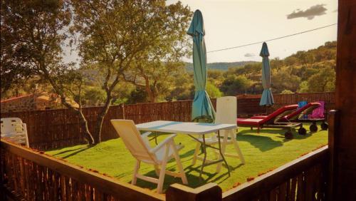 a patio with a table and chairs and umbrellas at Casa Rural con skatepark y piscina " La Quijada del Lobo " in Llerena