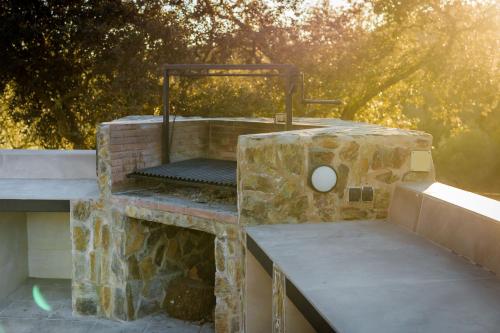 a stone grill sitting on top of a stone table at Casa Rural con skatepark y piscina " La Quijada del Lobo " in Llerena