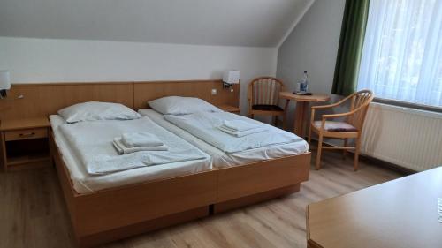 a bedroom with a bed and a table and chairs at Haus Waldesruh in Petersdorf