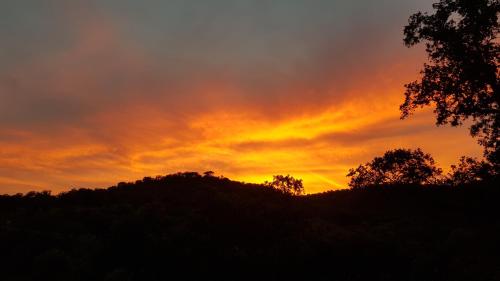 a sunset over a hill with trees in the foreground at Casa Rural con skatepark y piscina " La Quijada del Lobo " in Llerena