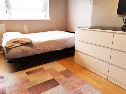 a bedroom with a bed and a dresser and a window at Charming London Town Studio Flat, Tower Bridge in London