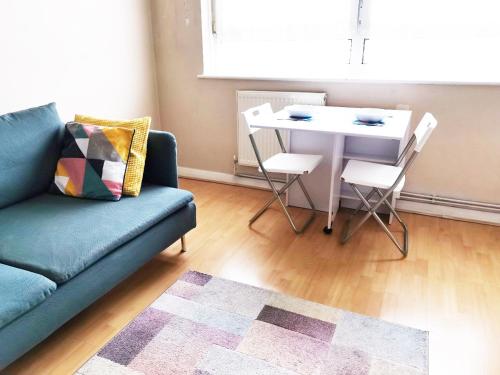ein Wohnzimmer mit einem Sofa und einem Tisch in der Unterkunft Charming London Town Studio Flat, Tower Bridge in London