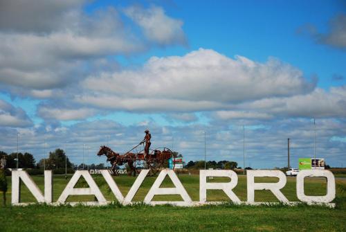 un hombre montando un caballo detrás de una gran señal en Apartamentos Laguna de Navarro en Navarro