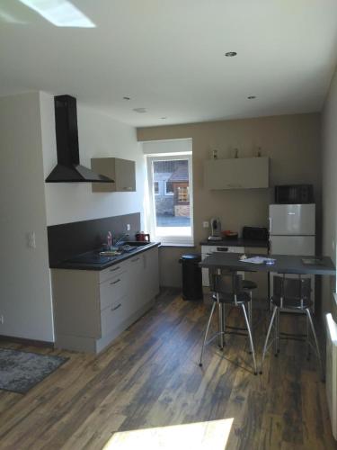 une cuisine avec une table et des chaises dans une pièce dans l'établissement Le Studio Polichinelle, à Gérardmer