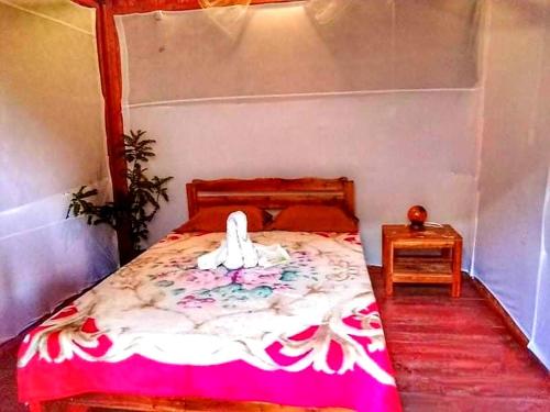 a bedroom with a bed with a pink and white blanket at SHUKRAN Apartelle in Siquijor
