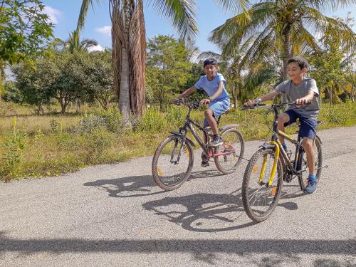 two young boys riding bikes down a road at VAMA Retreats in Bengaluru