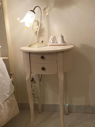 a table with a lamp on it next to a bed at B&B Paradiso San Vincenzo in Molfetta
