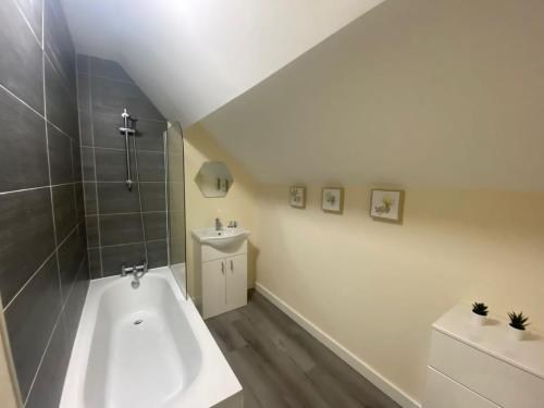 a bathroom with a bath tub and a sink at Hodge Bower Holidays - Ironbridge, Squires in Ironbridge