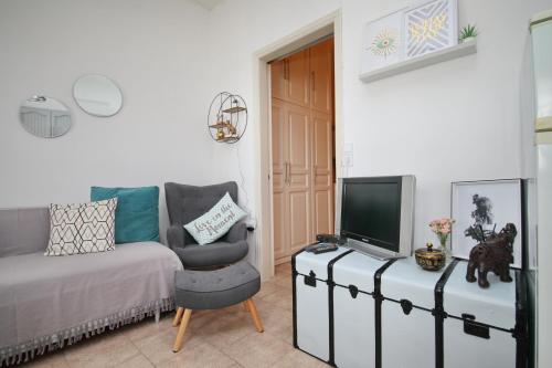 a living room with a couch and a tv at Vanilla guesthouse in Skopelos Town