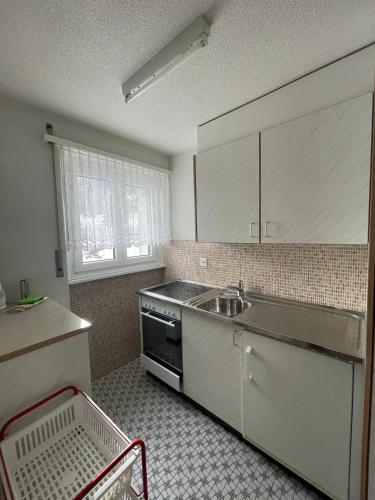 a kitchen with a sink and a stove at Haus Atlantic Leukerbad in Leukerbad