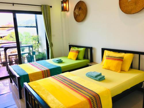 メーサリエンにあるMae-Sa-Riang Homeのベッド2台が隣同士に設置された部屋です。