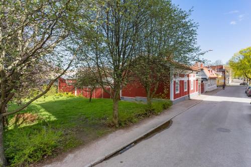 an empty street with trees and a red building at Gårdshuset mitt i centrala Gävle in Gävle