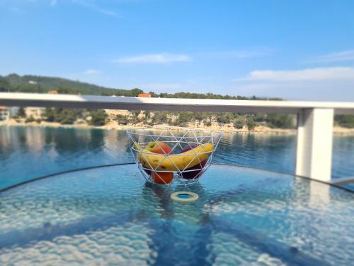 a bowl of fruit sitting on top of a body of water at Apartments Habek in Vrboska